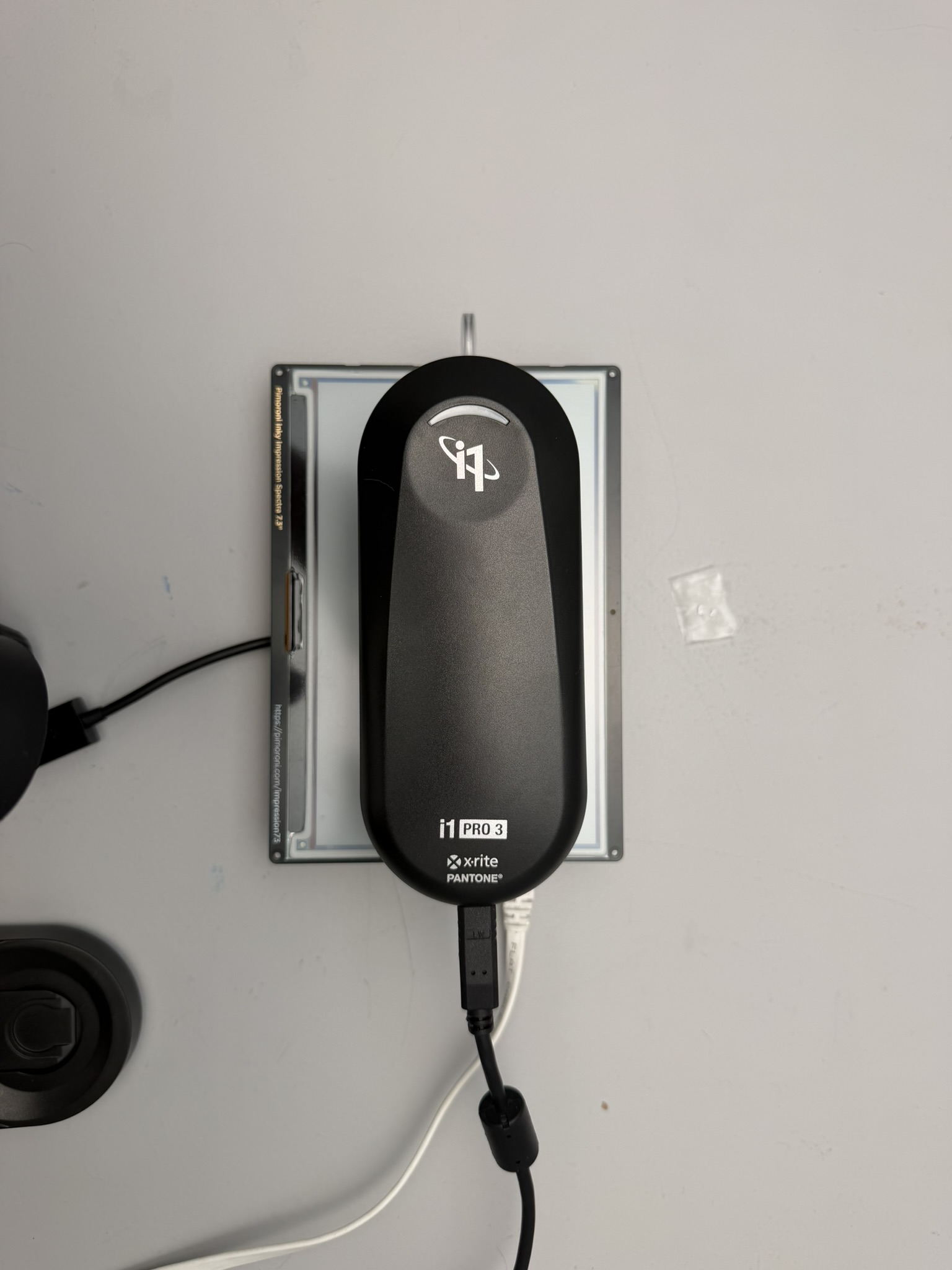 X-Rite i1Pro 3 positioned against the Spectra 6 display, seen from above